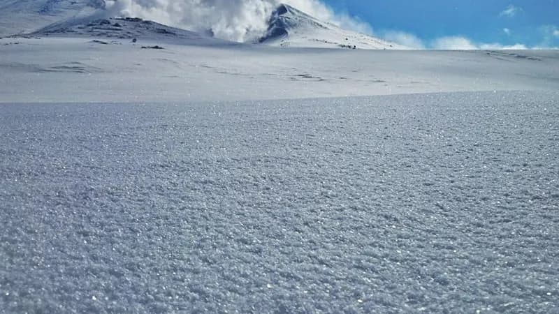 羽毛雪の雪原と噴気を上げる旭岳